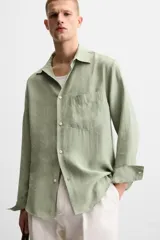 Camisa verde claro de corte relaxed fit confeccionada en tejido con mezcla de modal. Tiene cuello italiano, manga larga con puños abotonados, bolsillo de parche en el pecho y cierre frontal abotonado.