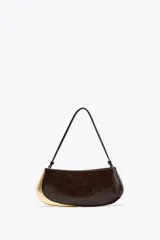 Bolso de hombro marrón oscuro con detalle metálico dorado en un lateral. Tiene un bolsillo interior con cremallera, asa de hombro y cierre con cremallera.