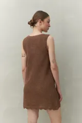 Vestido de tejido con trama abierta y caída liviana, confeccionado en un hilado con acabado metalizado. Silueta recta y sin mangas.