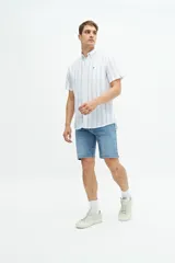 Camisa de manga corta a rayas verticales celestes y blancas, confeccionada en lino y algodón, con logo bordado en el pecho y corte regular.