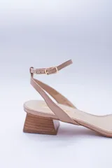 Sandalias de cuero negro con tira delgada sobre los dedos, pulsera al tobillo con hebilla dorada y taco geométrico color madera.
