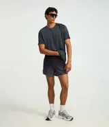 Bermuda deportiva de poliéster color gris oscuro, modelo running, con cintura elástica ajustable con cordón interno, bolsillo trasero con cierre y estampado degradado.