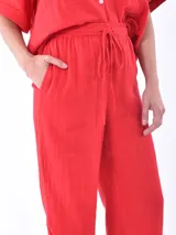 Pantalón de lino color rojo, de corte amplio y cintura elastizada con cordón ajustable.