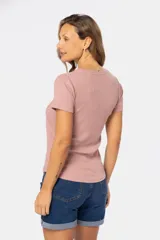 Remera color rosa con textura acanalada, cuello redondo y botones frontales.