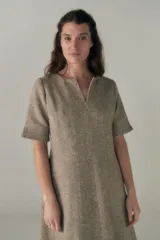 Vestido a la rodilla color beige, con escote en V, mangas cortas con detalle de tajo, bolsillos laterales y forro interior.