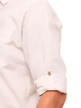 Camisa manga larga color beige claro de RKF, confeccionada en algodón orgánico. Tiene cuello italiano, cierre con botones de madera, bolsillo en el pecho con logo bordado y mangas ajustables con botones.