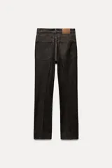 Jeans de tiro alto color negro, corte slim fit y bootcut, con cinco bolsillos y cierre frontal con cremallera y botón.