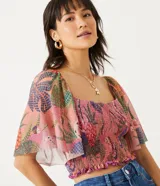 Blusa cropped de tul con estampado de guacamayos y piñas, escote cuadrado, mangas amplias fruncidas y lastex en el cuerpo.