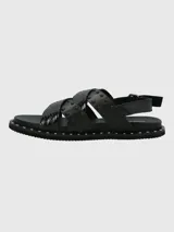 Sandalias negras de cuero con tiras cruzadas y tachas plateadas.