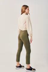 Pantalón chupín color verde oliva, con tiro alto y corte tobillero.