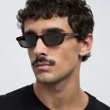 Lentes de sol unisex con montura rectangular carey y lentes polarizadas negras. Fabricados con materiales bio-based G850 y patillas de propionato de celulosa. Ofrecen protección UV400 categoría 3.