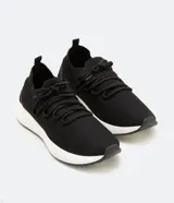 Championes de poliéster negro con suela blanca, cierre con cordones y tirador en el talón.