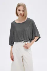 Remera manga corta color gris con lurex, de corte holgado y cuello redondo.