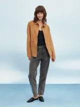 Sobrecamisa color beige, de corte recto, con cuello camisero, cierre frontal con botones a presión, mangas largas con puños abotonados, dos bolsillos de parche en el pecho y bajo recto.