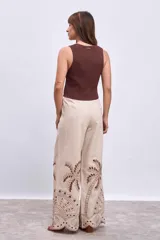 Chaleco tejido de punto color blanco, sin mangas, con escote en V y cierre frontal de botones dorados.