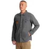 Campera gris de algodón canvas, estilo camisa, con bordado de un sol en el bolsillo del pecho. Tiene dos bolsillos con solapa en el pecho y cierre con botones. Corte recto y holgado.