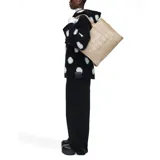 Bolso tote grande de lona color beige con asas de mano y estampado frontal con el texto "THE TOTE BAG MARC JACOBS" en blanco.