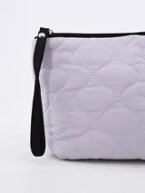 Necesser de forma rectangular, color lila pálido, con textura acolchada con costuras onduladas. Posee cierre superior negro y una correa de mano negra.