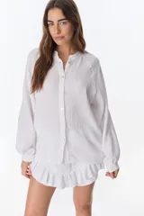 Camisa beige de manga larga con botones y detalles de encaje.