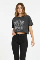 Remera cropped negra de algodón con cuello redondo y mangas cortas. Estampado frontal con texto "Rooted Rock & Roll" y diseño de águilas.