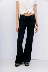 Pantalón jean de tiro medio, calce ajustado, con proceso de coating de acabado símil cuero y pierna levemente acampanada.