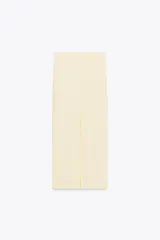 Falda midi color crema, de tiro alto con cintura elástica y detalle de pliegues laterales.