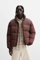 Campera puffer marrón con cuello alto, cierre frontal con cremallera, bolsillos laterales y puños elásticos.