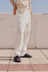 Pantalón blanco de lino y algodón, corte recto, con cintura elástica ajustable con cordón, bolsillos laterales y trasero.