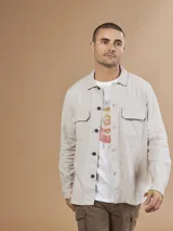Camisa color verde militar de manga larga con cuello clásico, cierre frontal con botones y dos bolsillos de parche en el pecho.