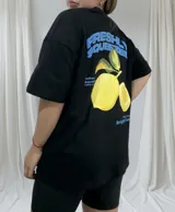 Remerón negro de corte holgado con estampado en la espalda de dos limones amarillos con hojas verdes y texto en azul que dice "Freshly Squeezed".