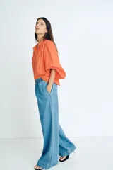 Pantalón culotte de denim azul claro, con cintura elástica fruncida, bolsillos laterales y corte holgado.