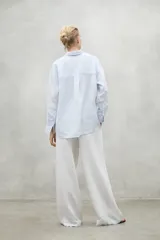 Camisa celeste con rayas verticales blancas, de lino.