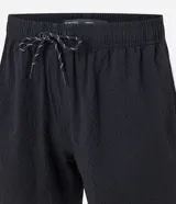 Bermuda de microfibra color beige, con cintura elástica y cordón ajustable. Presenta textura en el tejido y un bolsillo lateral.