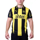 Camiseta de fútbol Puma del Club Atlético Peñarol, modelo Home. Diseño a rayas verticales amarillas y negras con detalles en negro en cuello y mangas. Incluye logo de Puma, escudo del club y sponsor Antel en el frente.