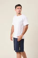 Bermuda deportiva de nylon color verde militar, de corte suelto, con cintura elástica, cordón de ajuste, detalles de líneas en los costados y bolsillos con cierre.