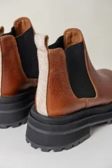 Borcegos negros de cuero vacuno con elástico lateral, suela track y tirador trasero.