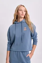 Canguro azul con capucha, cordón ajustable y bolsillo tipo canguro. Estampado en la espalda con imagen de Sebastián de La Sirenita y texto "Crab-ulous".