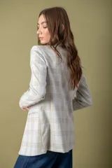 Blazer gris claro con estampado a cuadros en tonos beige, con solapas de muesca, cierre frontal con un botón y corte recto.