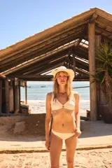 Traje de baño de dos piezas color crema, con corpiño triangular con aro forrado y push up removible, y bombacha clásica.