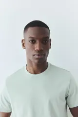 Remera verde agua de punto liviano con cuello redondo ribeteado y bajo recto. Corte estándar confeccionada con COOLMAX®, fibra sintética que transporta el sudor del cuerpo a la superficie del tejido.