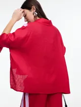 Camisa de lino color negro con silueta amplia y mangas 3/4. Diseño con tiras de color blanco en contraste en la cartera, mangas y cuerpo. Tiene tajos laterales y ruedo irregular en el frente.