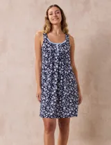 Camisón corto sin mangas, con estampado floral en tonos blanco y celeste sobre fondo azul marino. Presenta escote redondo con detalle de puntilla celeste y botones.