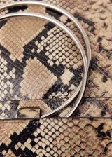 Bolso tipo shopper con estampado animal print, anilla metálica y asa de mano.