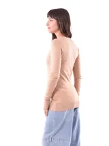 Sweater de punto color beige, de corte ajustado y mangas largas.