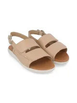 Sandalia color beige con capellada de cuero, suela blanca y ajuste con hebilla.