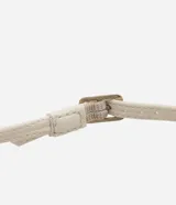 Sandalias de tacón alto color crema, con punta redonda abierta, tira fina con hebilla en el tobillo y maxi lazo decorativo en la parte delantera.