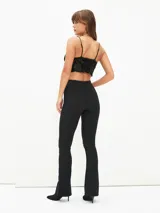 Calza ajustada color rojo oscuro, de tiro alto y tejido acanalado, con corte acampanado en el tobillo.