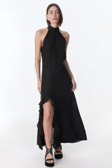 Vestido largo negro con cuello halter, abertura lateral con volados y espalda descubierta.