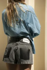 Short de jean celeste con efecto degradé simulando los bolsillos y terminación desflecada.