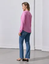 Blusa rosa de lino marca Zac & Rachel, con cuello a la base, escote en V y abertura central con botones. Tiene bolsillos delanteros y mangas largas regulables con presilla y botón.